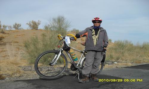 70岁的老翁骑游在沙漠公路上