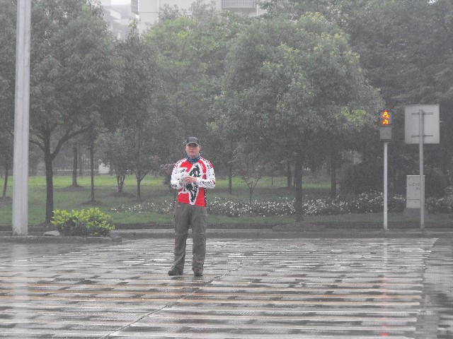 杭州后勤人员铁涛在雨中摄像
